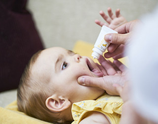 druppeltjes in mond van baby doen